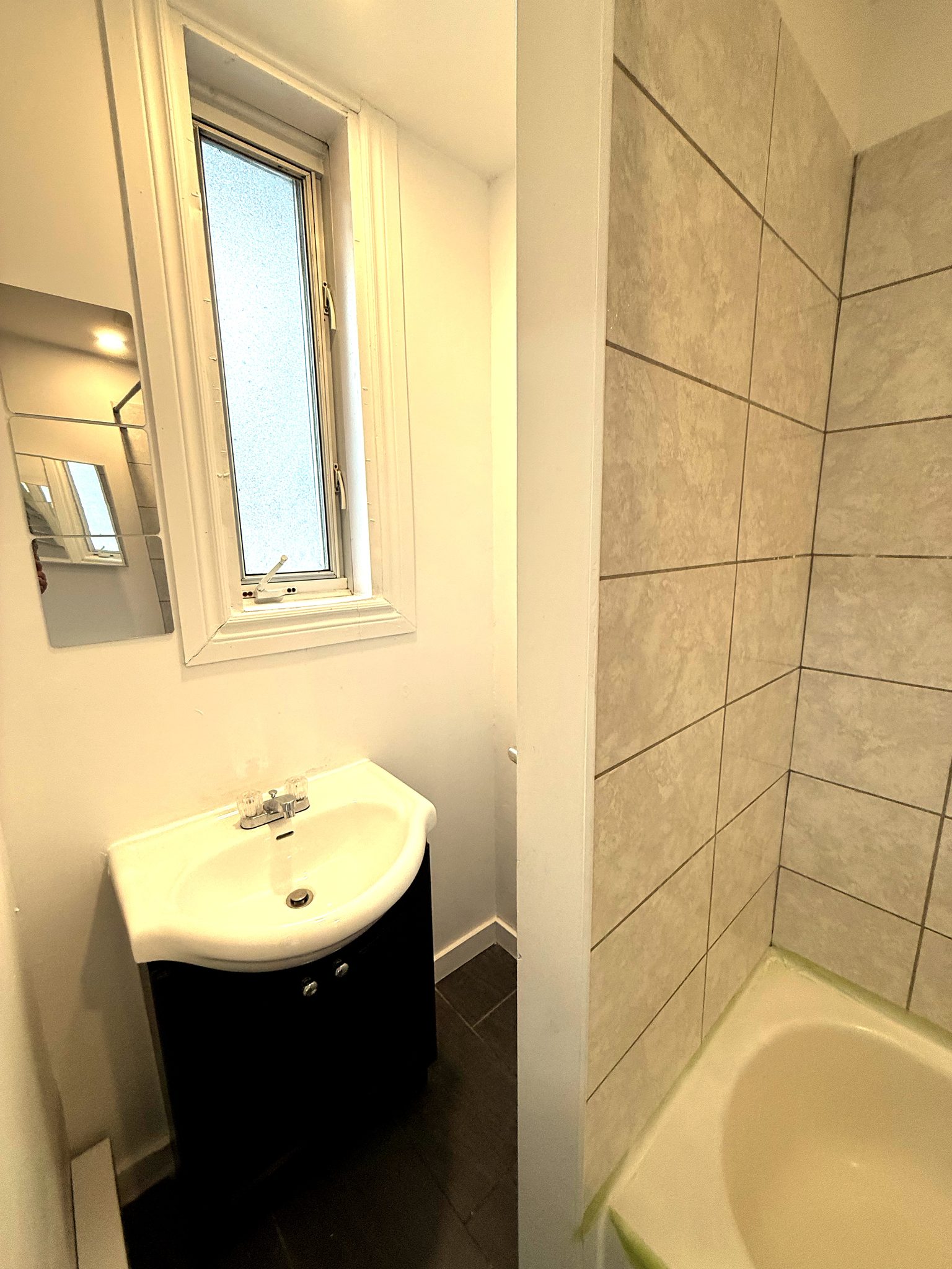 Vanité de la salle de bain, miroir rond et céramique beige.