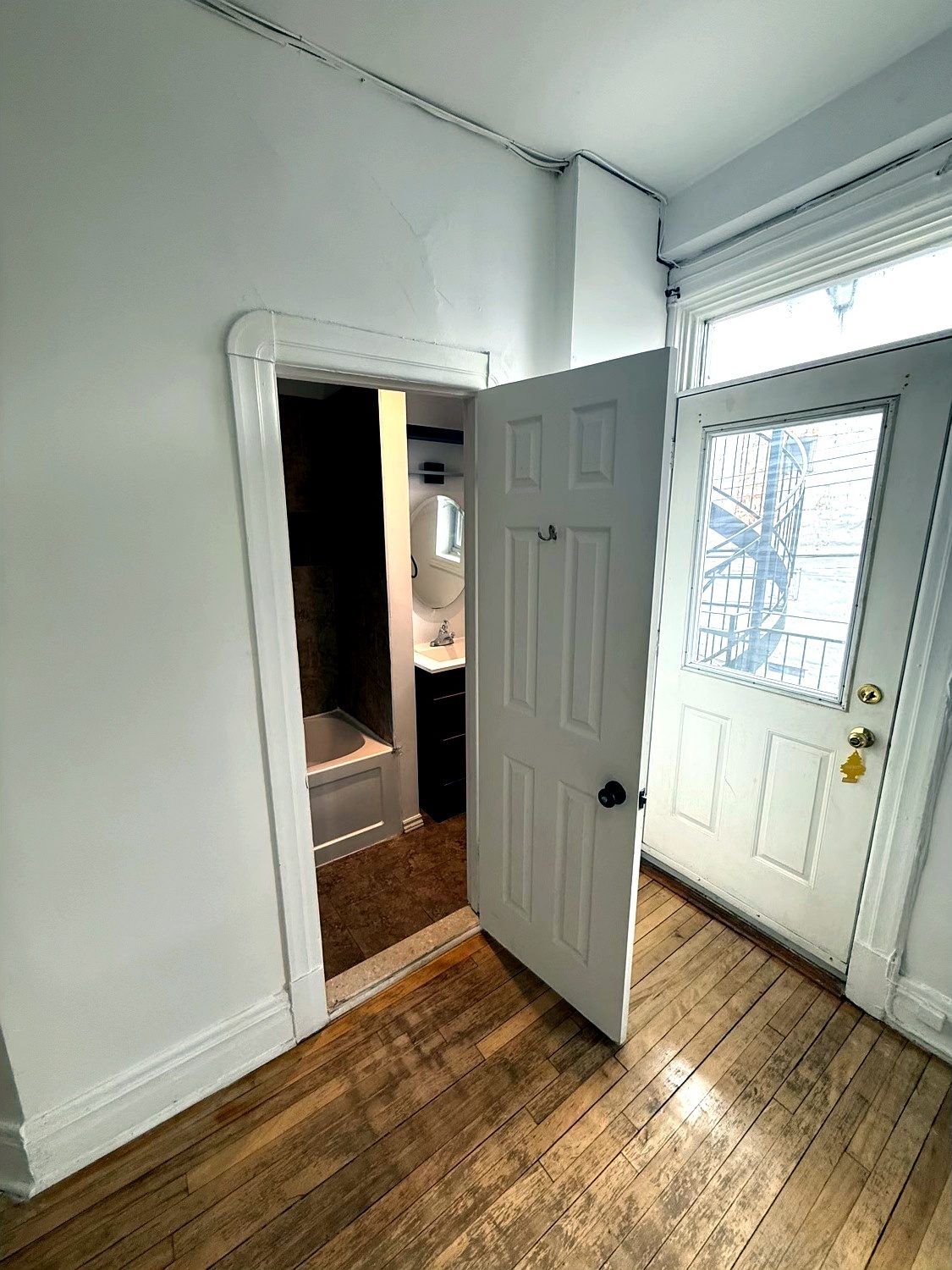 Palier arrière : porte de la salle de bain ouverte et porte donnant sur l’escalier extérieur.