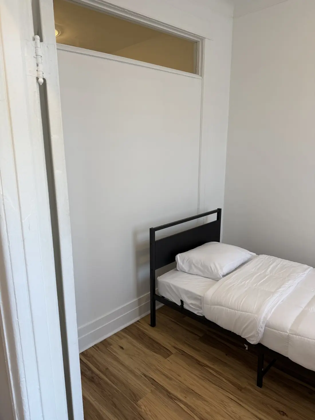 Deuxième chambre avec lit simple et plancher de bois franc.